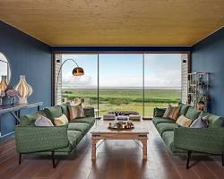 modern living room interior with a large fixed picture window overlooking a lush green backyard, warm afternoon sunlight streaming in, wide-angle lens, eye-level shot